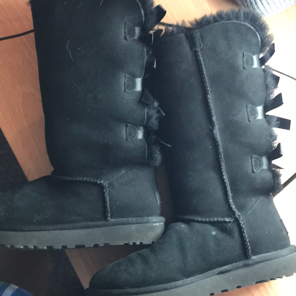 Black Tall Ugg boots with bows.